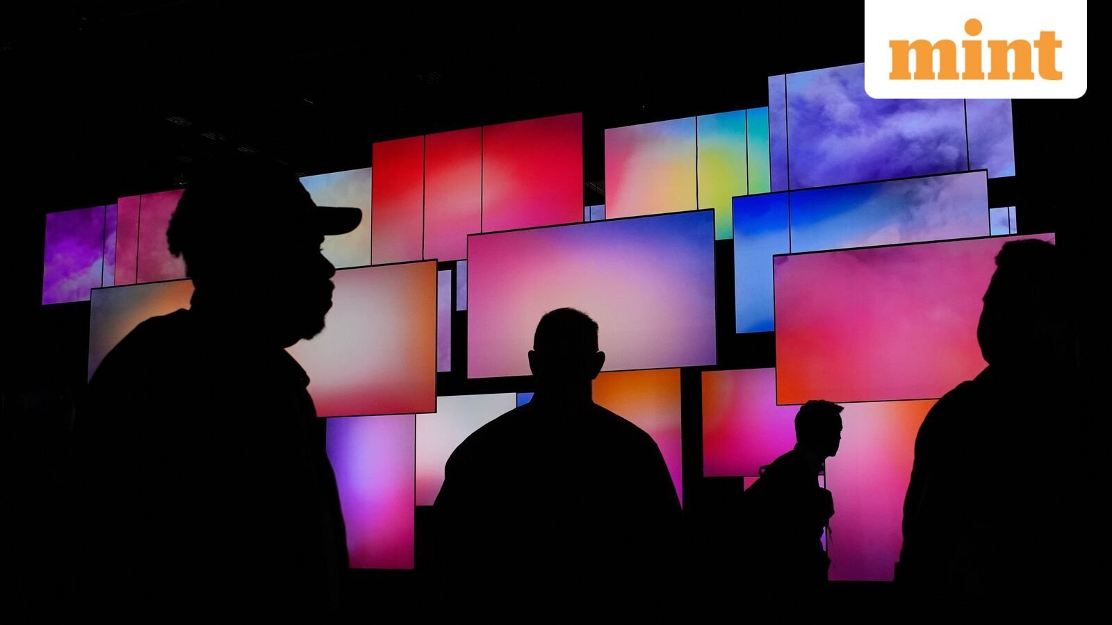 People walk past a wallpaper TV display at the LG booth during the CES tech show in Las Vegas. 
